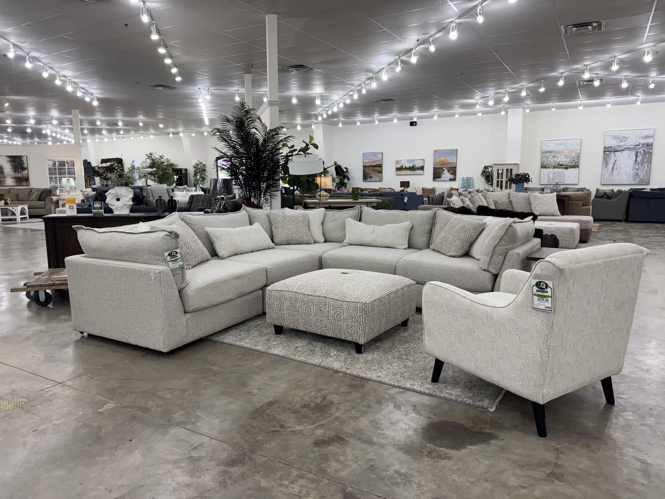 Oversized light gray sectional with chaise and ottoman on the LQ showroom floor
