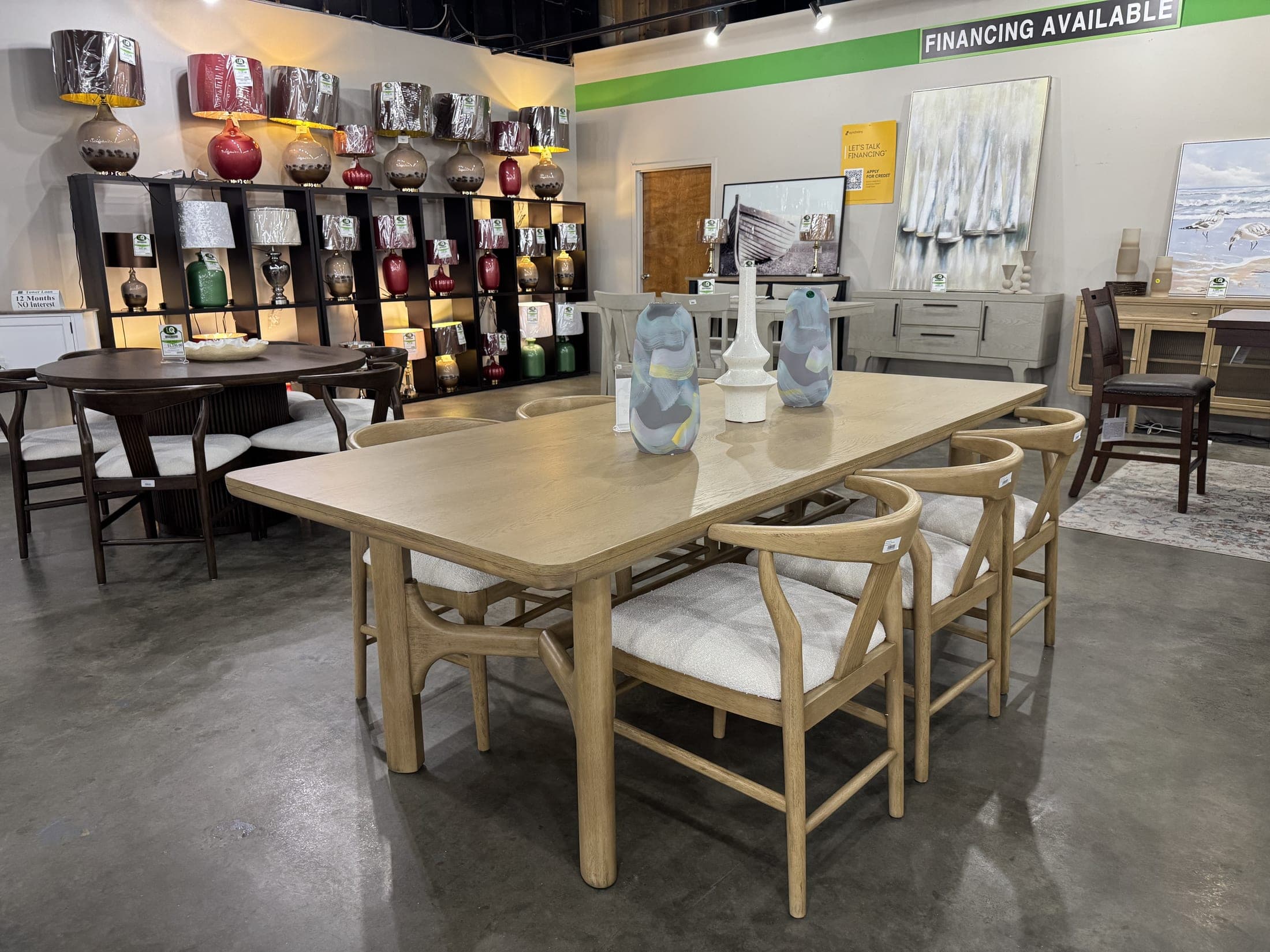 Light-finish dining table with woven-back chairs on the LQ Furniture floor