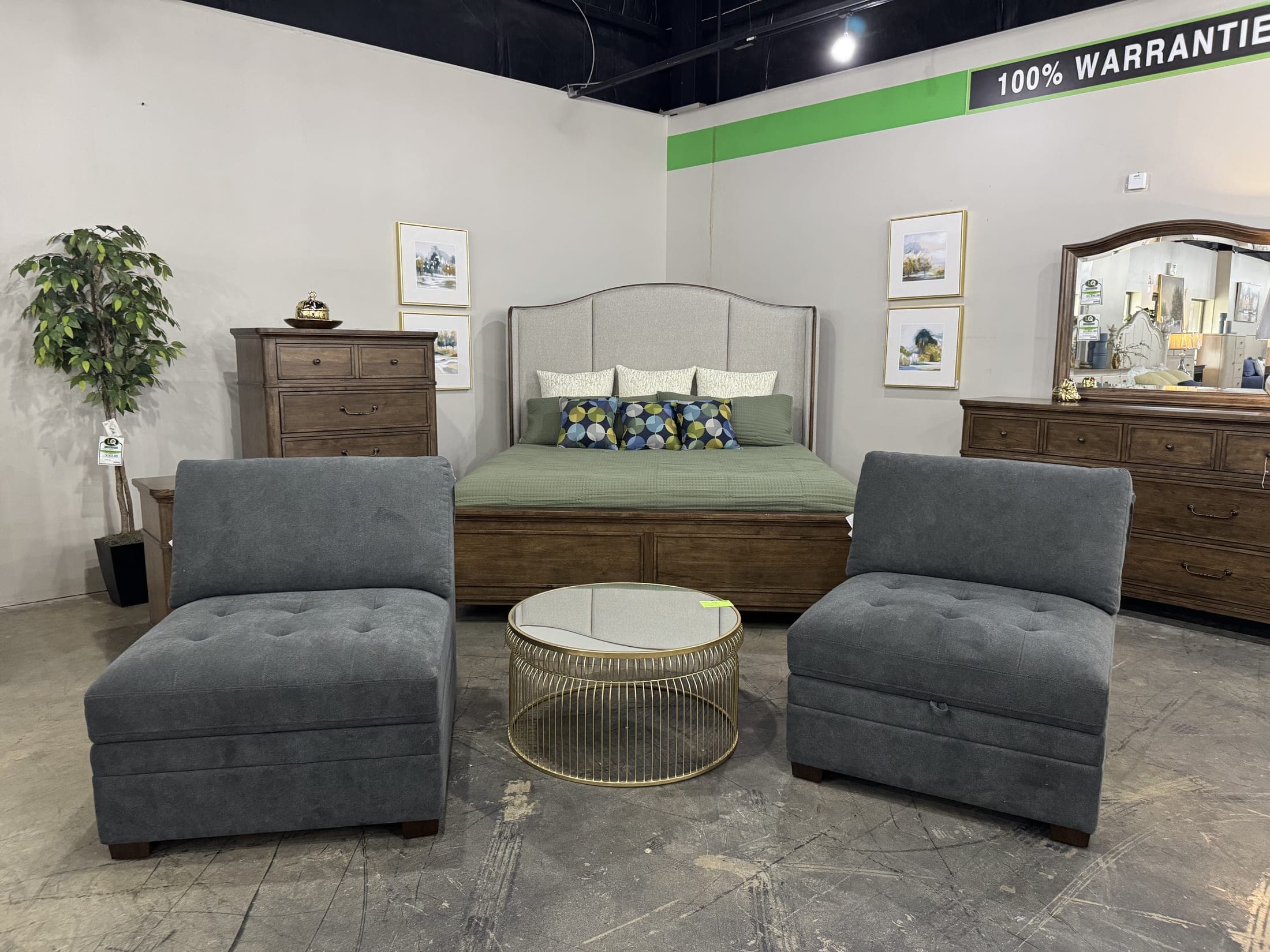 Upholstered headboard bed with wood chest and dresser, two gray armless chairs in front