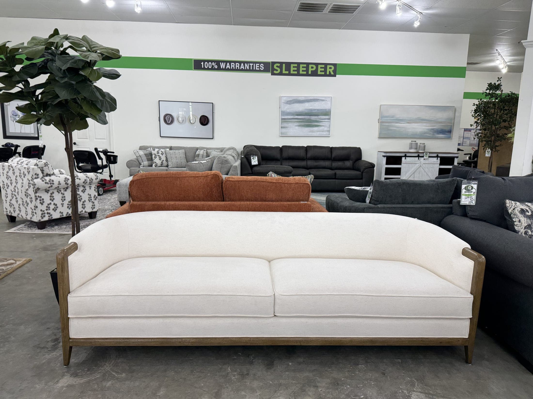 Cream sofa with exposed wood trim and nailhead detail on the LQ showroom floor